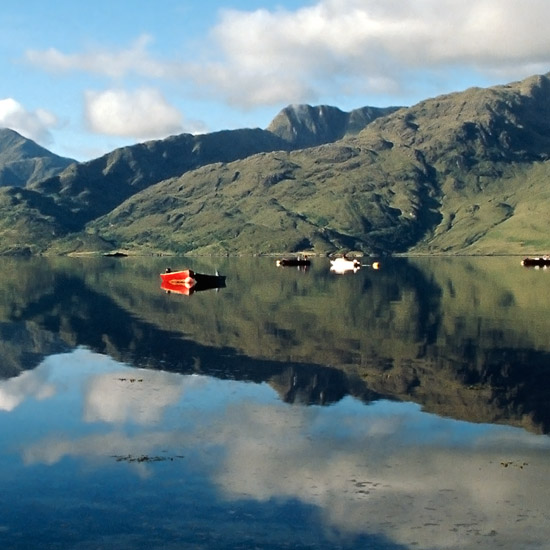 Zoom: An early morning view of Loch Hourn and Knoydart from Arnisdale, with our wee boat tied to the 'Arnisdale ferry'
