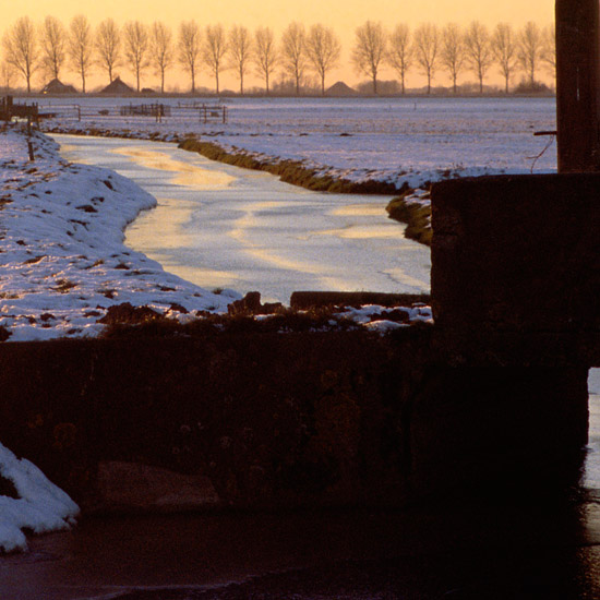 Zoom: Een bruggetje in de Kleine Waterling van de Beetskoog bij een winterse zonsondergang, van dichtbij