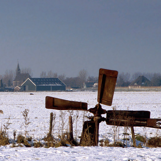 Zieltogend molentje in de sneeuw van de Beetskoog, met Oudendijk in de achtergrond